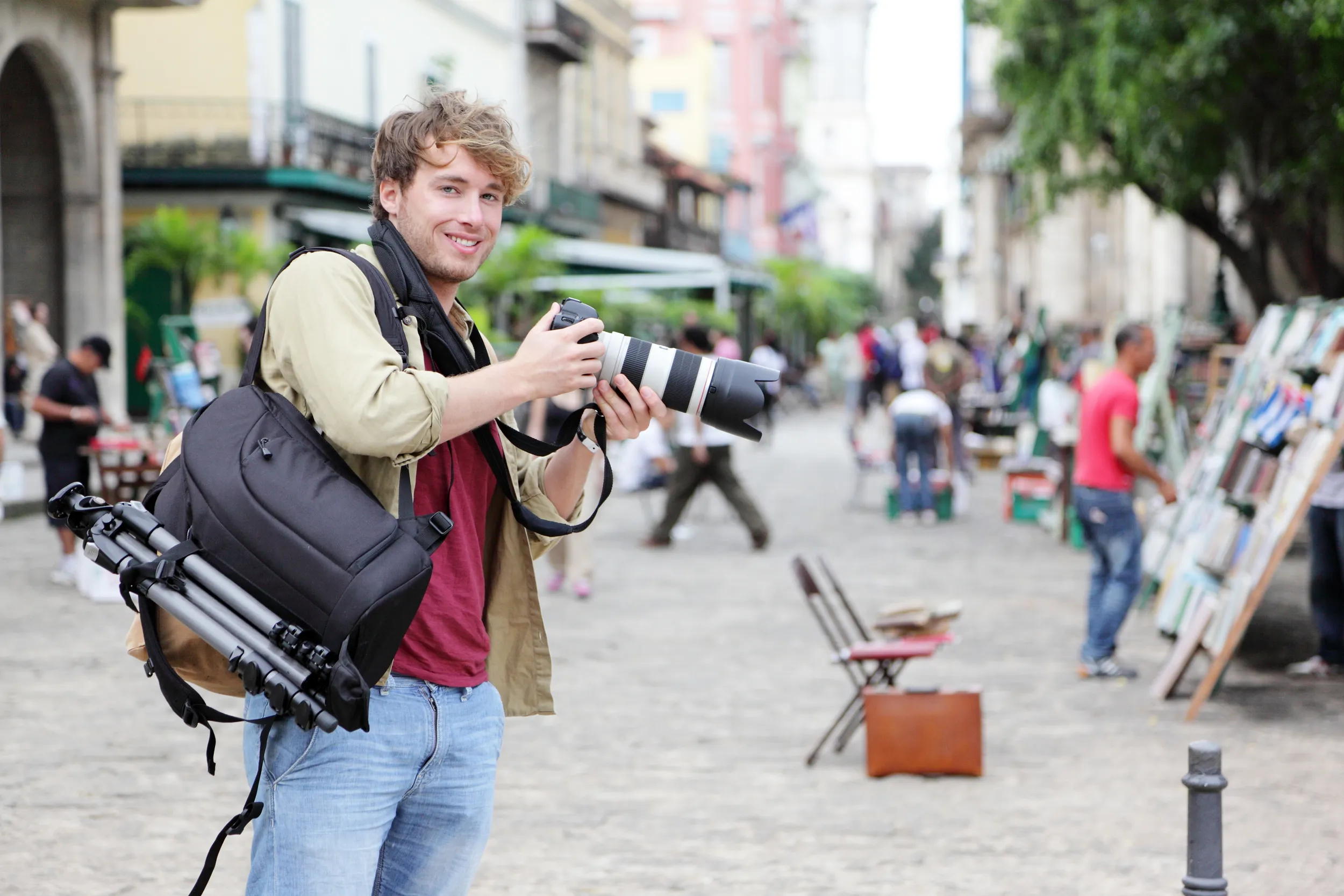 Uomo in viaggio con una macchina fotografica e l'attrezzatura fotografica