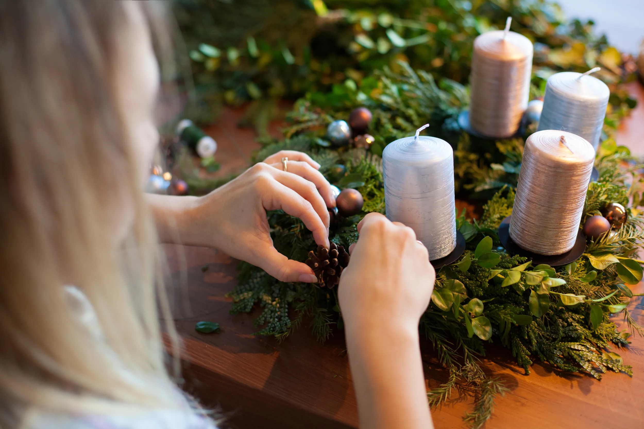 Una signora prepara una corona dell'Avvento