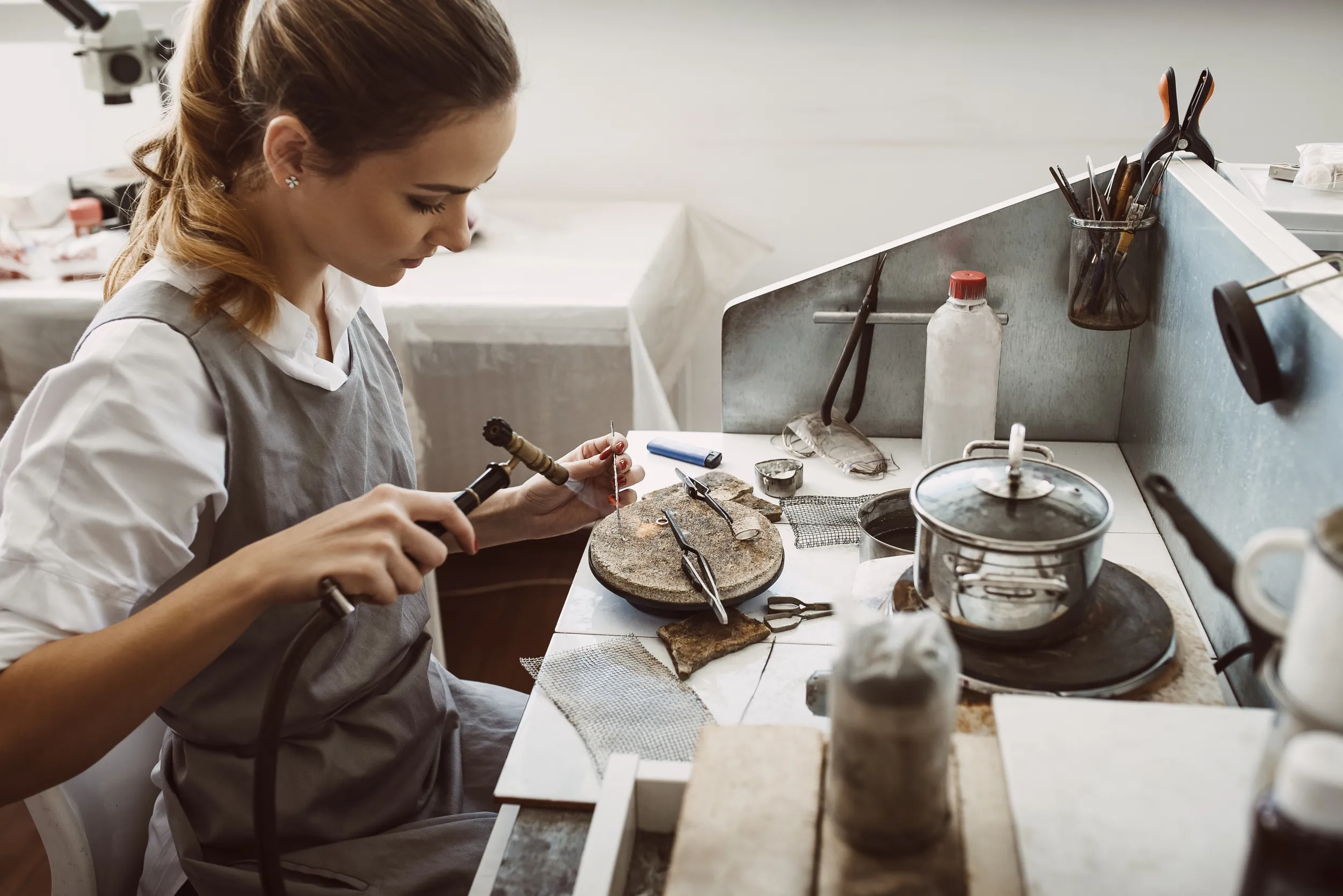 Una donna che crea gioielli e si dedica all'oreficeria