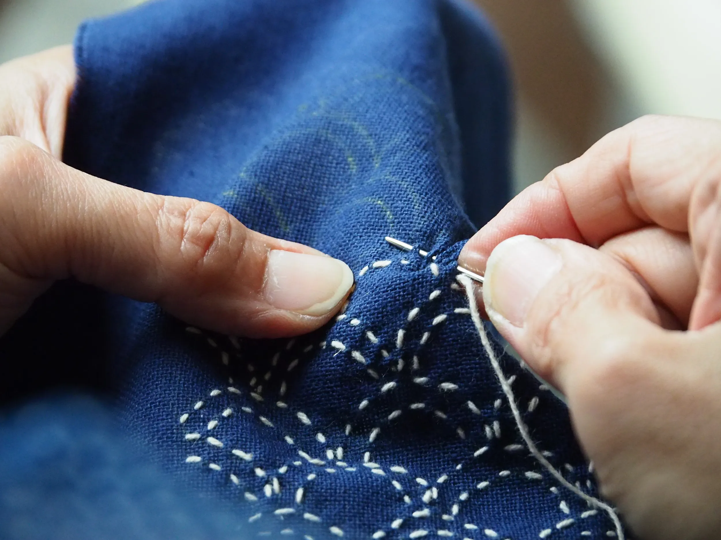 Una donna sta ricamando a sashiko