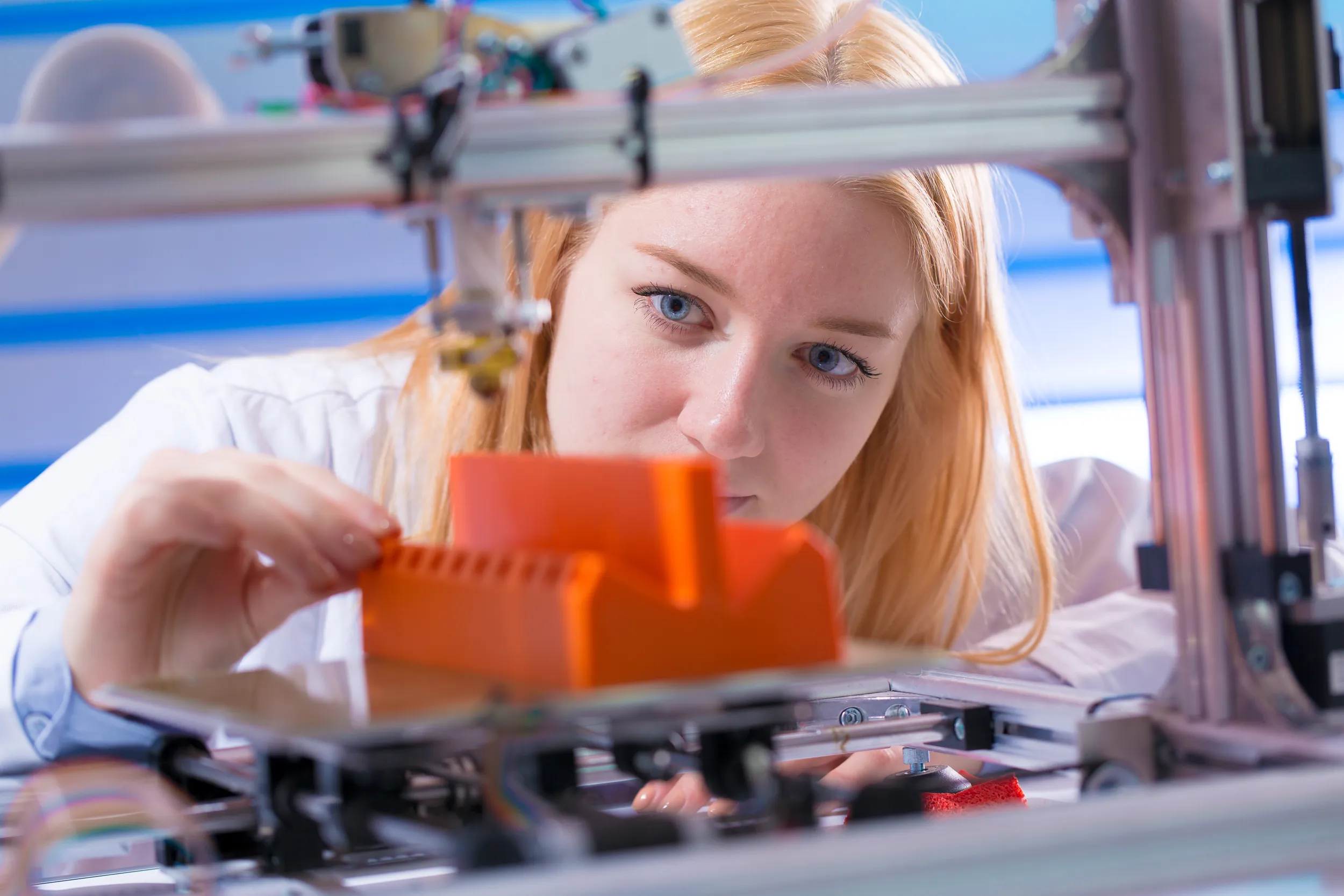 Una donna osserva una stampante 3D
