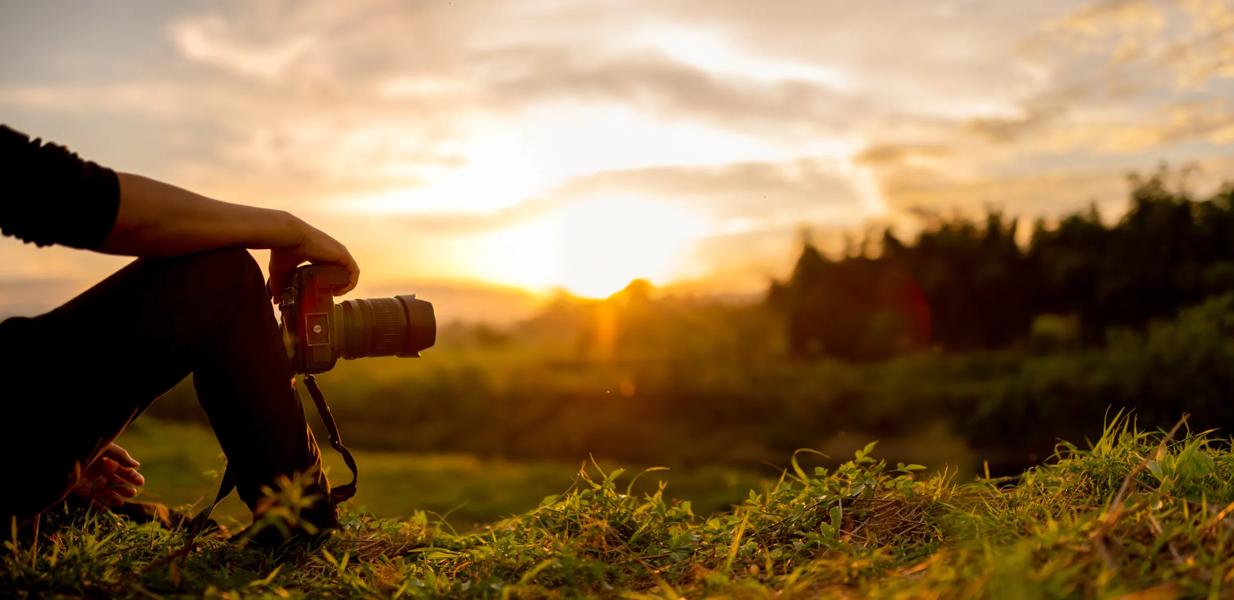 Uomo che fotografa il paesaggio al tramonto
